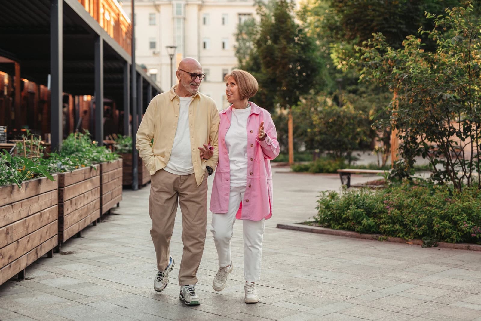 An older couple walking and talking outdoors