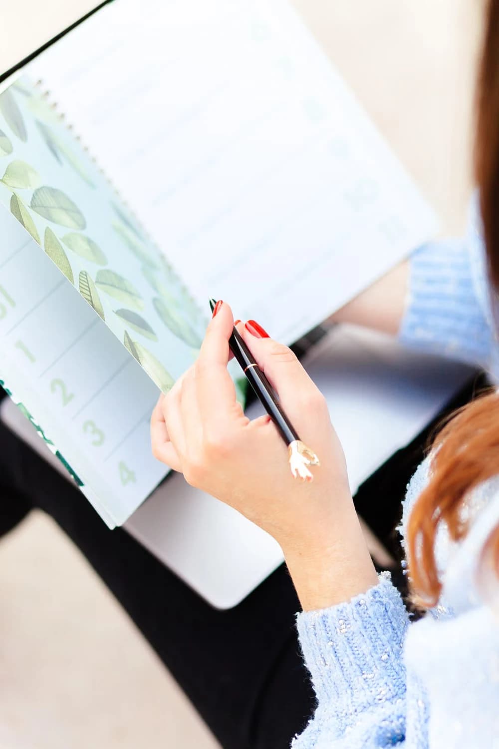Close-up of a woman writing in a planner
