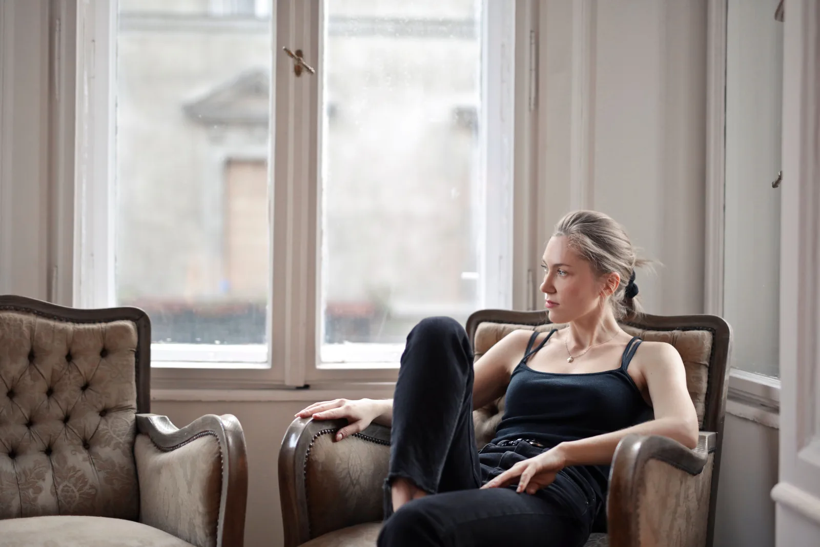 A woman resting in an armchair by a window
