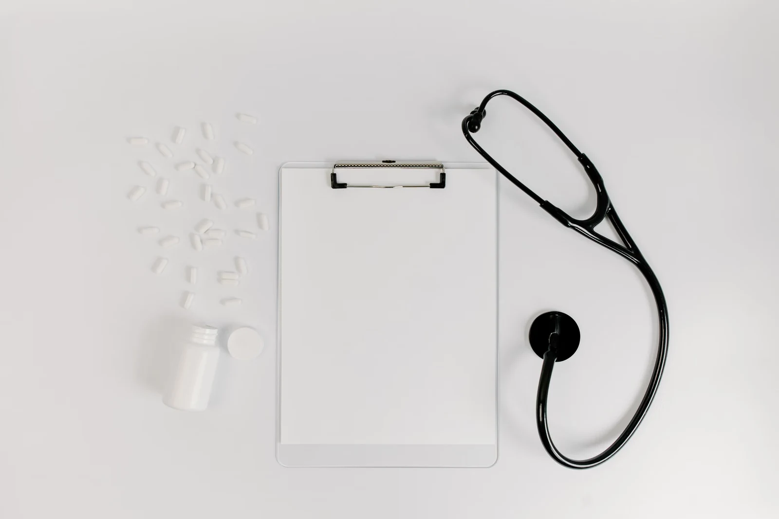 A clipboard, stethoscope, and medication for a health review