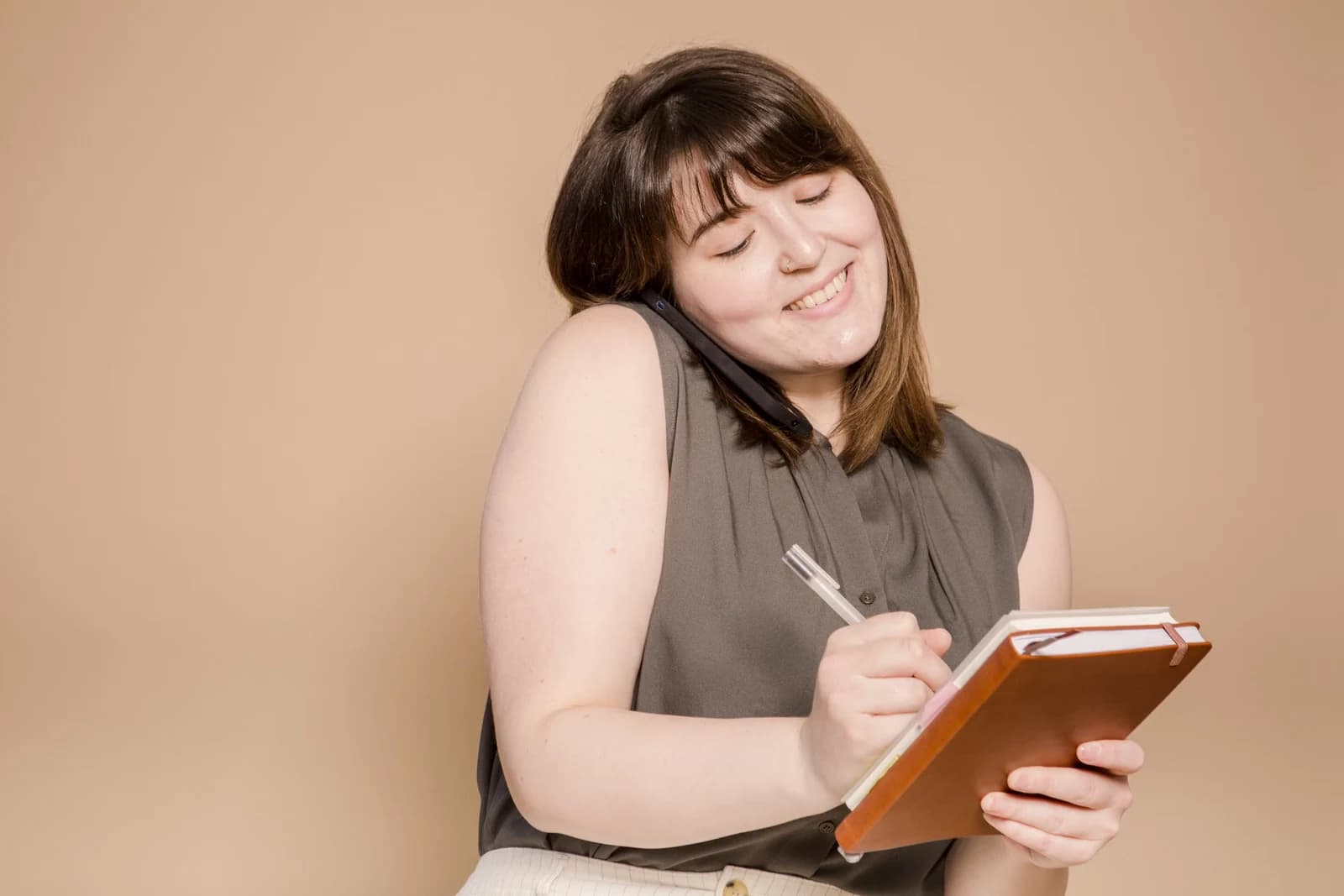 A woman taking notes during a phone call