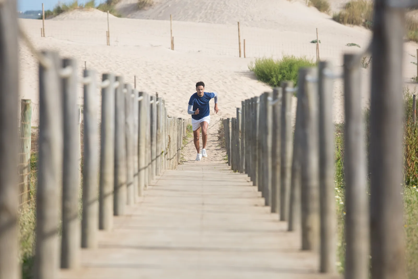 A man running along a beach boardwalk